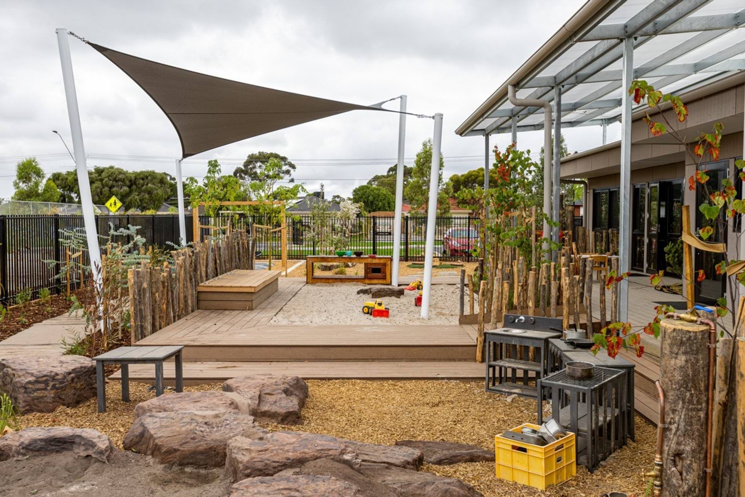 Movelle Kindergarten - photo of an outdoor play area with a sandpit and a shade sail