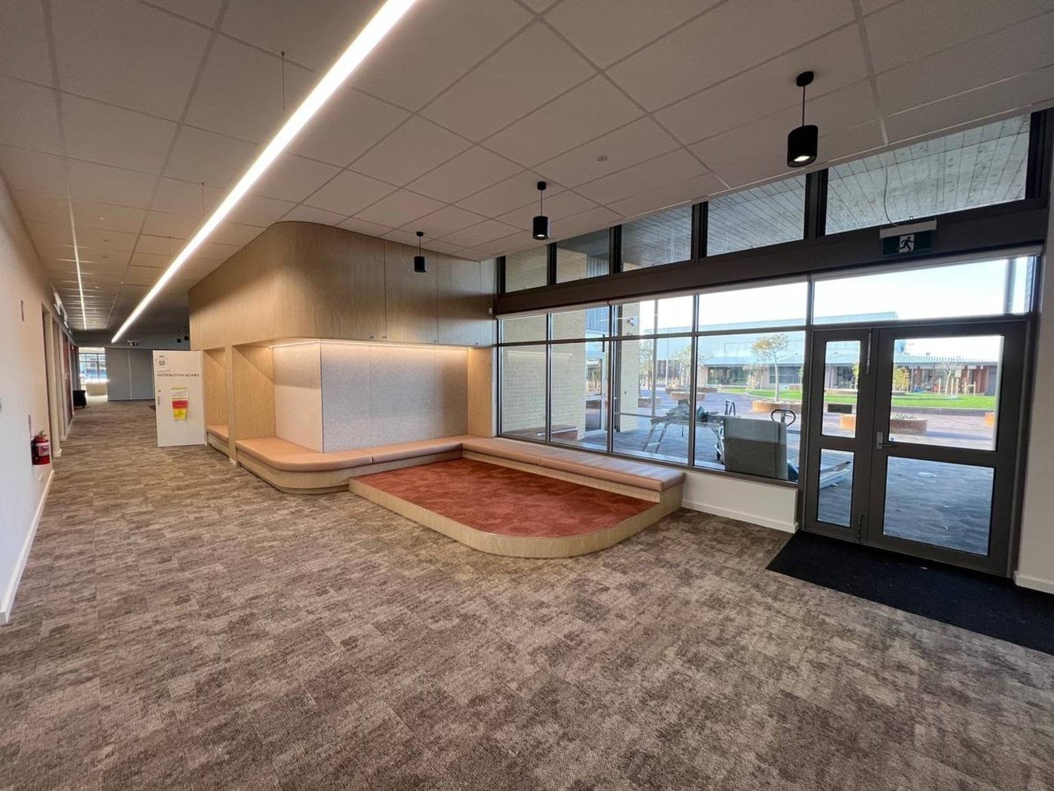 Interior entry point with grey carpeting and raised red carpeted area to the side