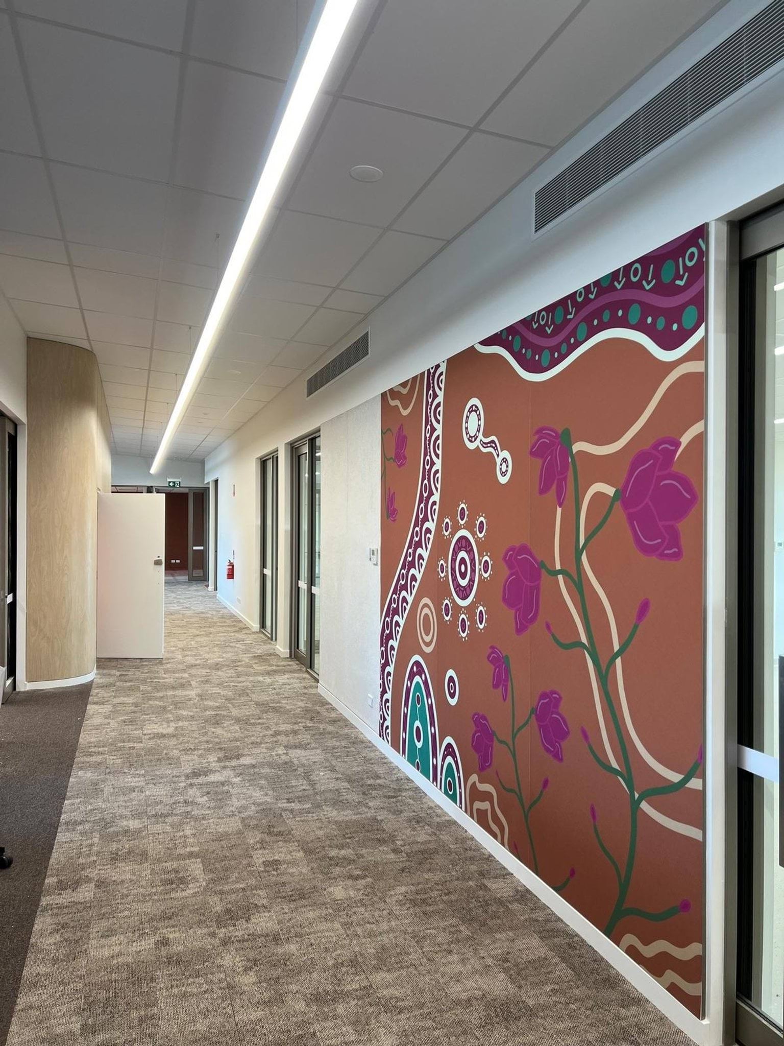 Flowers and indigenous Australian painting on a feature wall along the hallway