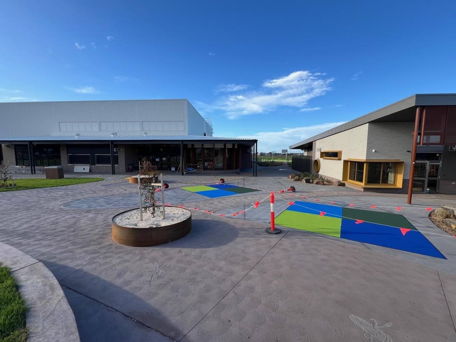 Brightly colour downball squares are throughout concreted playground area 