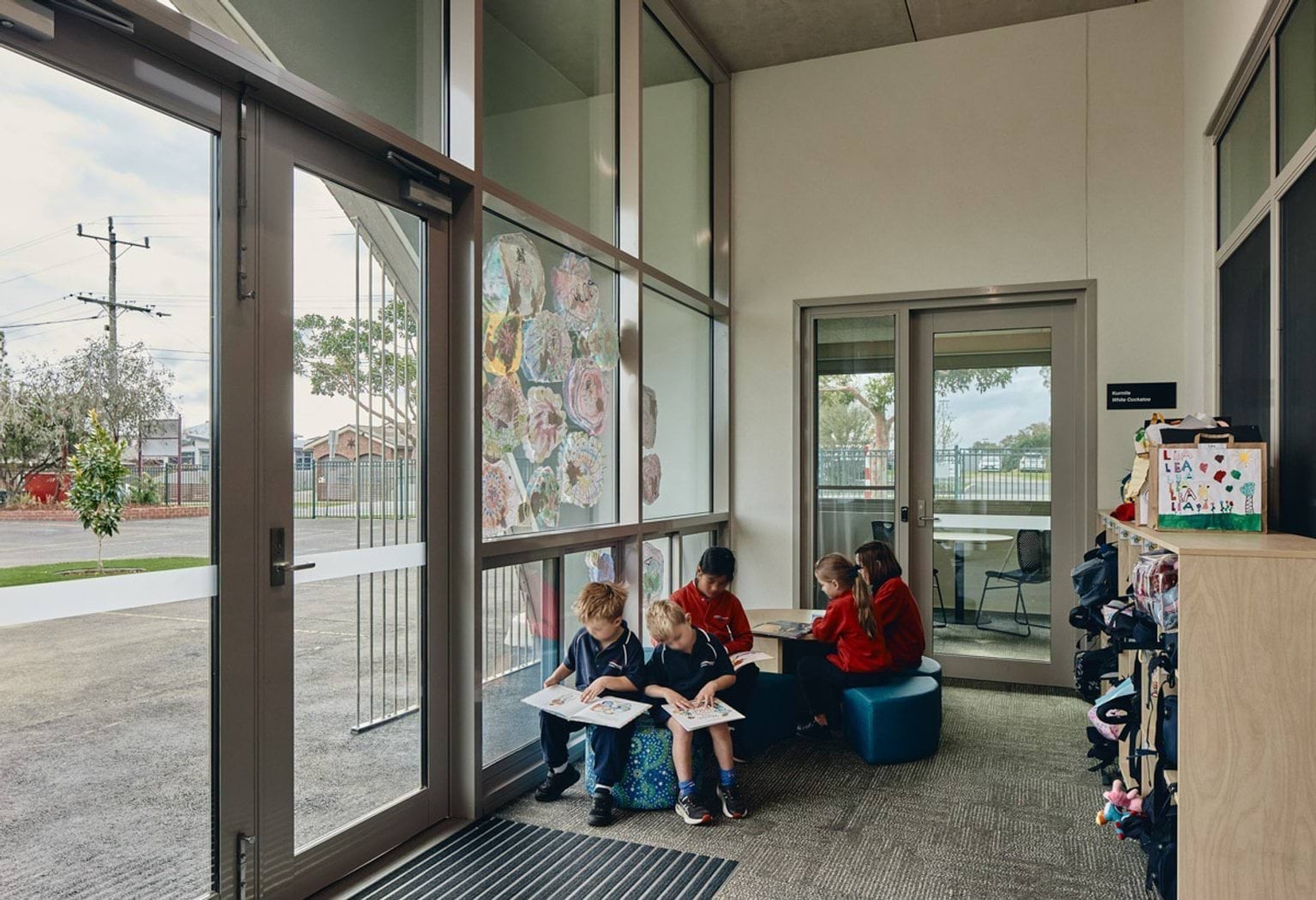 Inside classroom with group of school students sitting near window.
