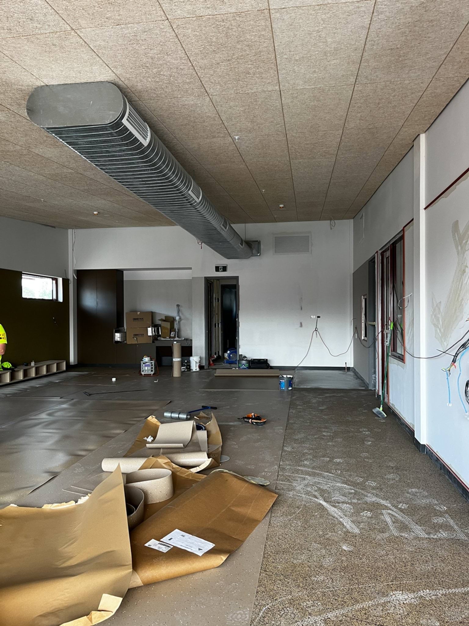Interior of kindergarten with metal vent running along the ceiling. 