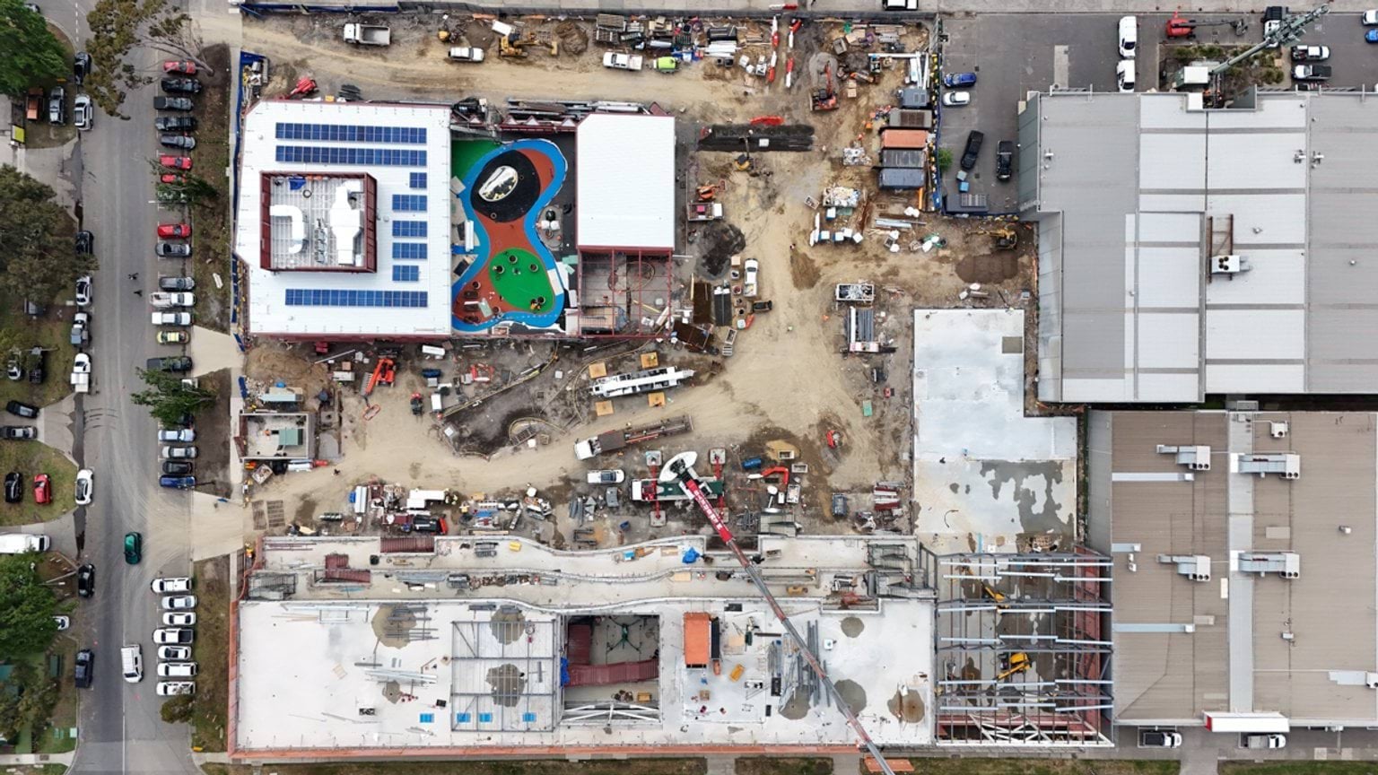 Birds eye view of building site with the Kindergarten in the second floor of the building highest in frame and the primary school throughout the remaining spaces.