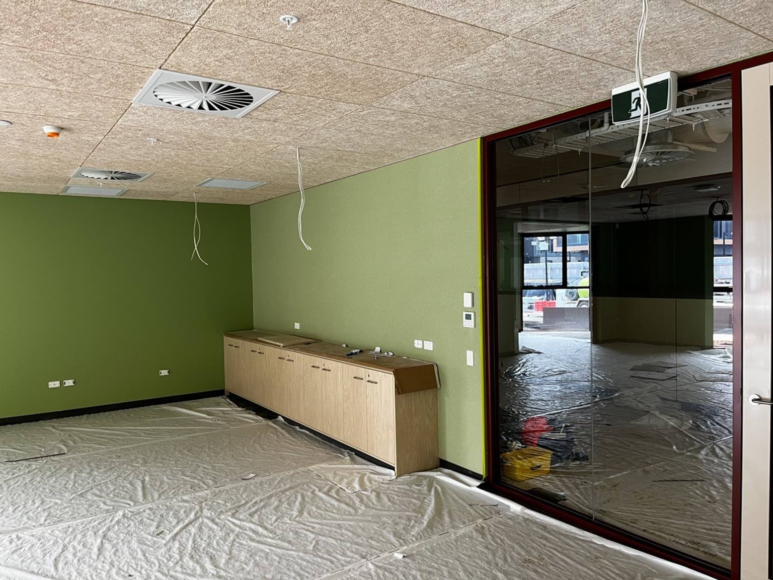 Interior of Narrarrang Primary School classroom with green walls, particle boards ceiling.  