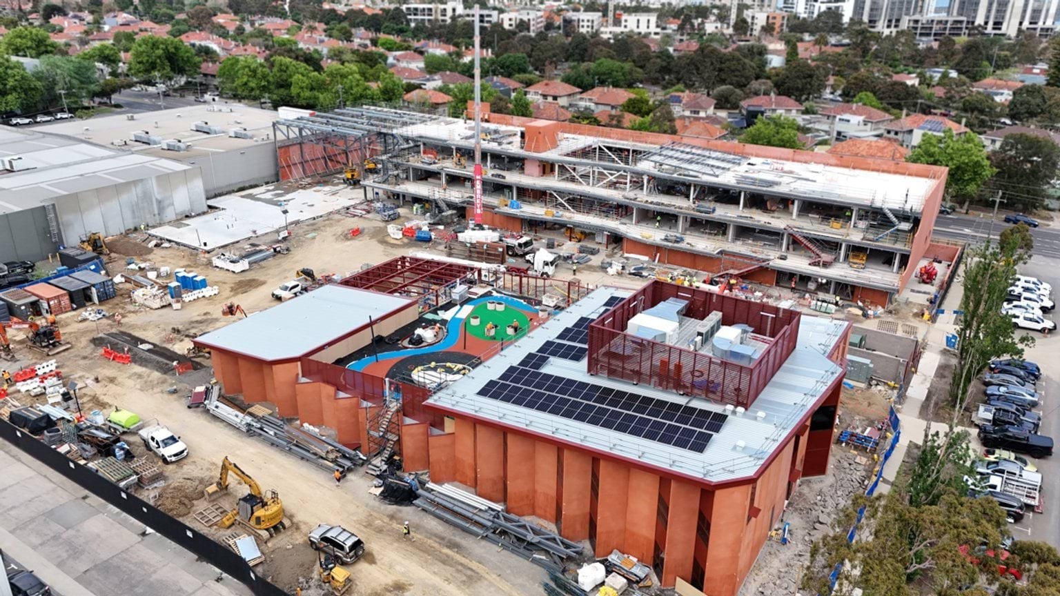 Aerial image of Narrarrang Primary School displaying ochre red wall panelling and solar panels on the roof. 
