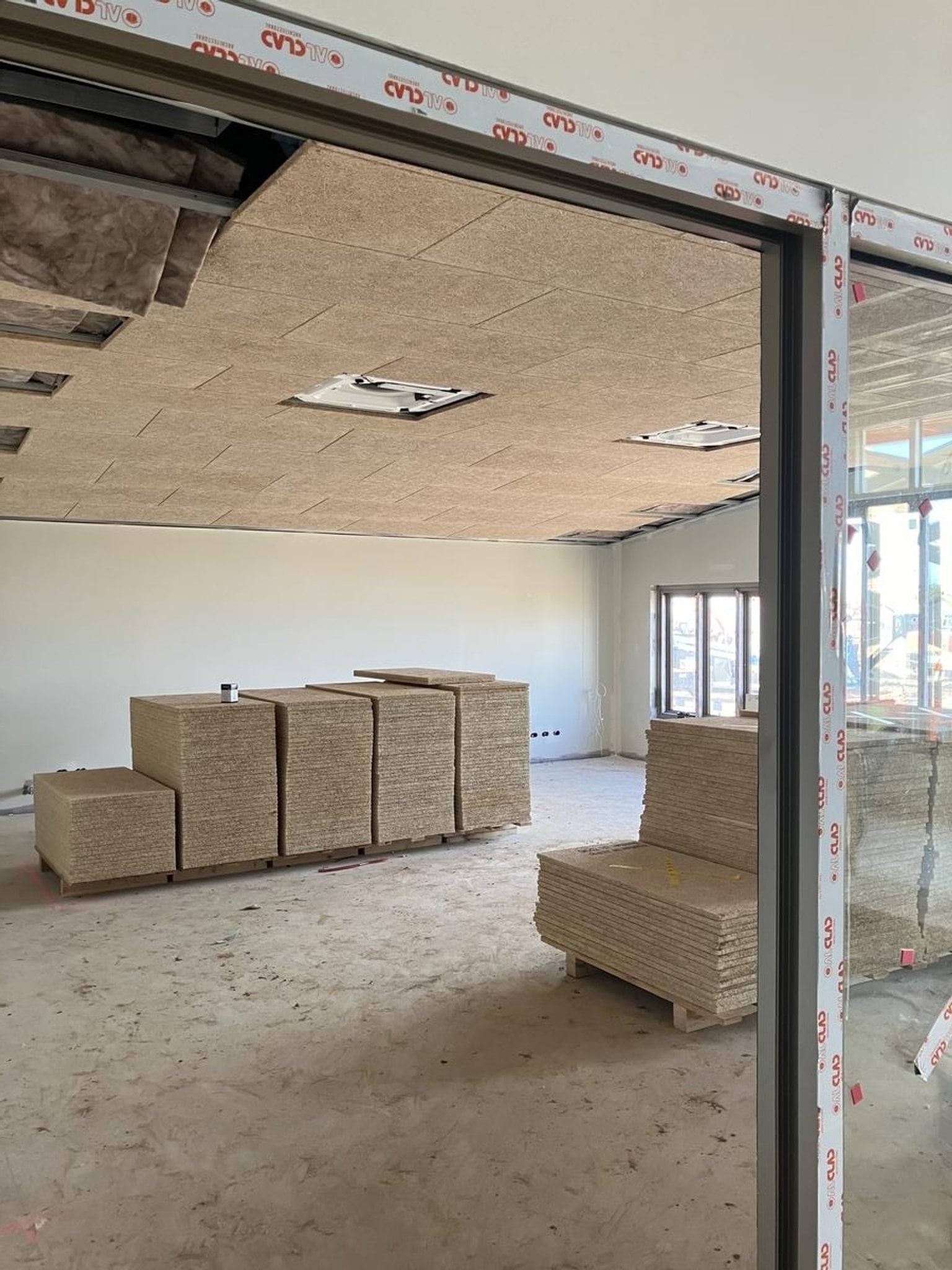 Piles of fibreboard on pallets with semi-complete ceilings. 