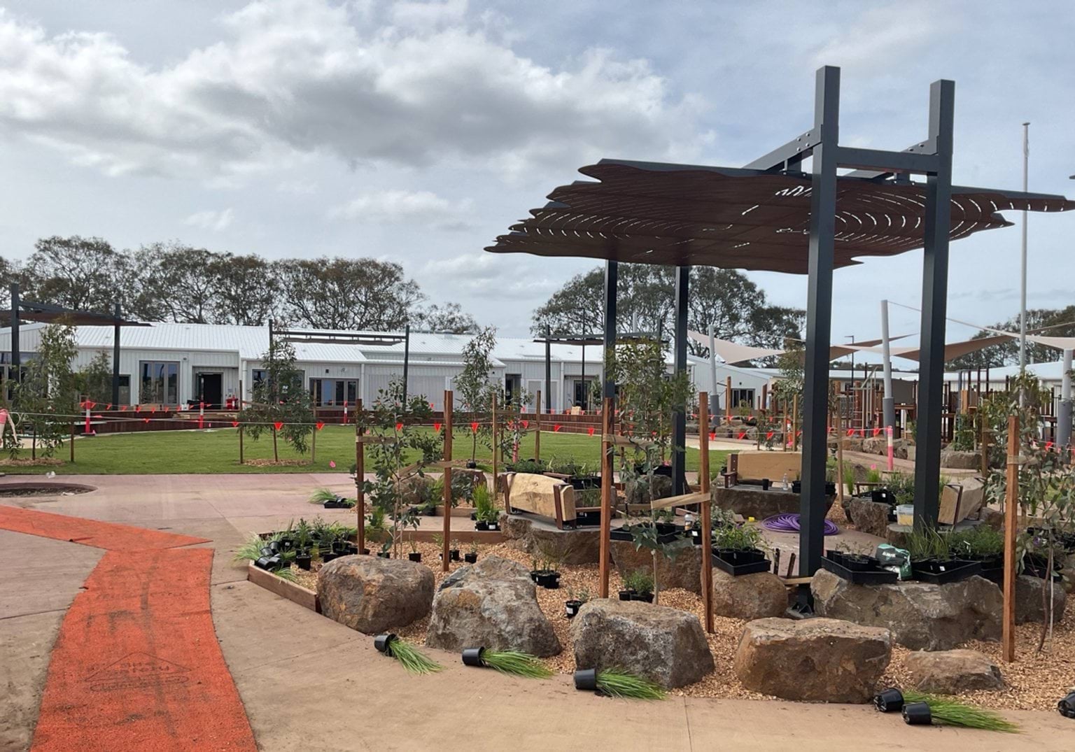 Biyala Primary School newly landscaped playground featuring boulders and a metallic sun shade with cut out shapes of local animals
