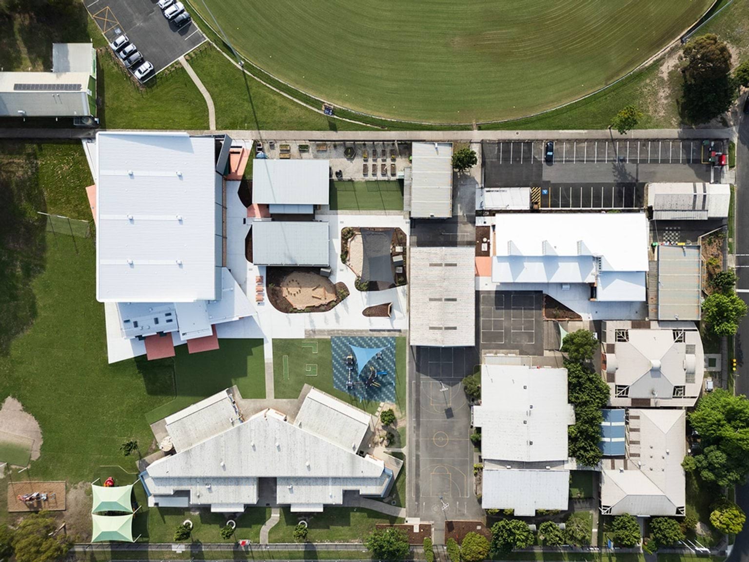 Aerial view of school campus showing multiple buildings, playgrounds, and sports fields.