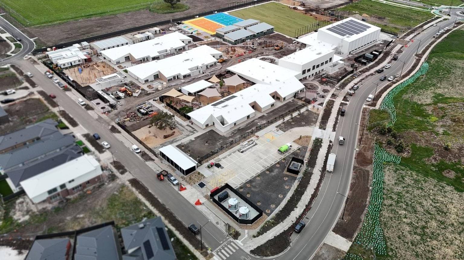 Aerial photo of school complex from road, highlighting carparks and front entrance