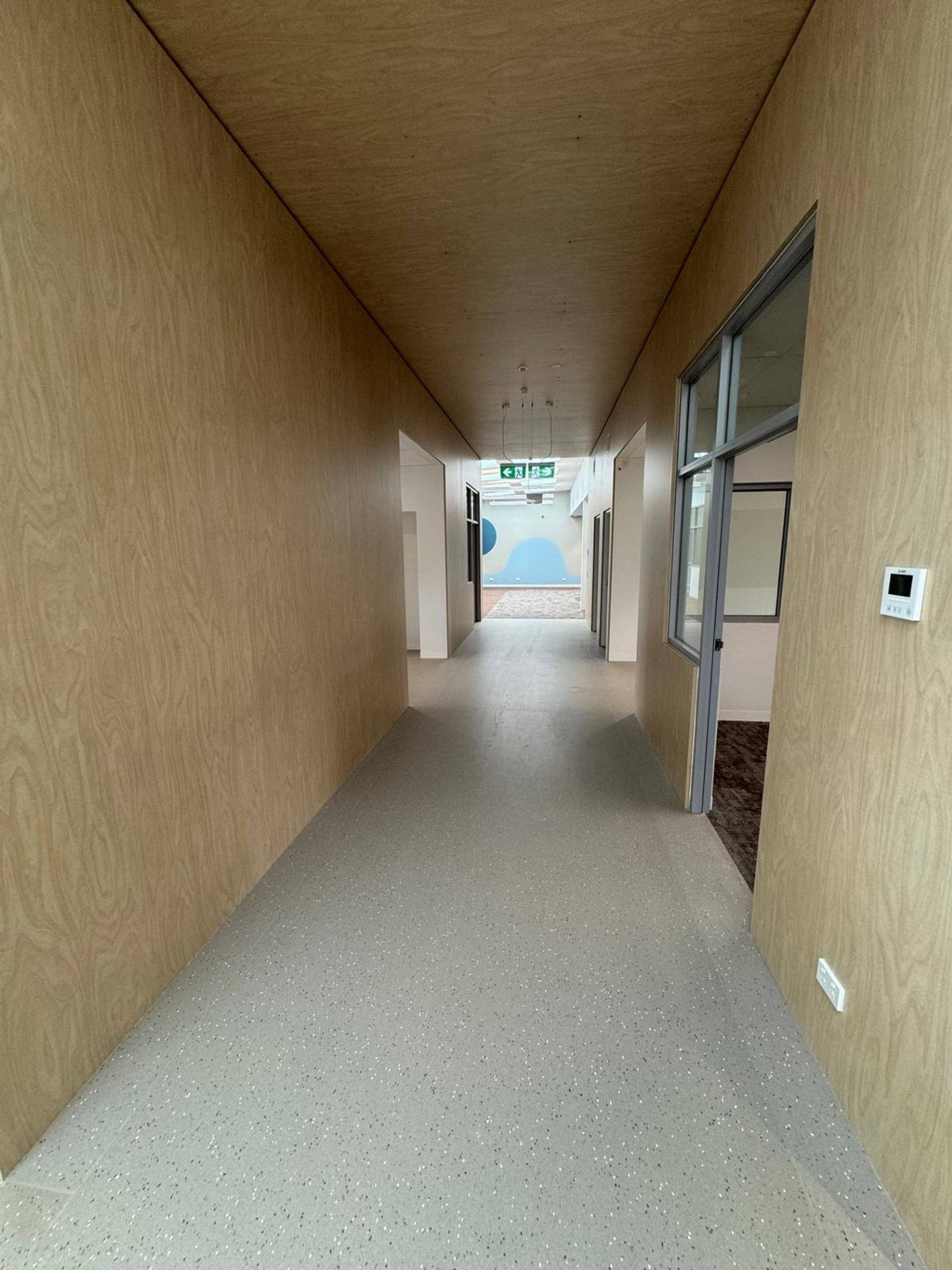 School hallway under construction. There's wood panel on the walls and ceiling.