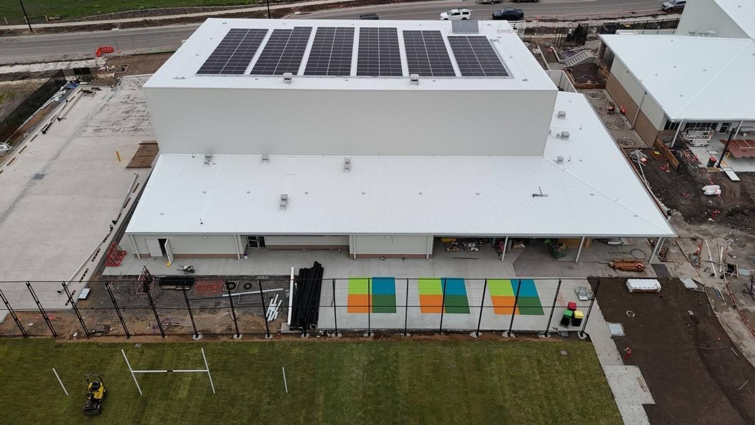 Overhead photo of school building with solar panels and outdoor play area