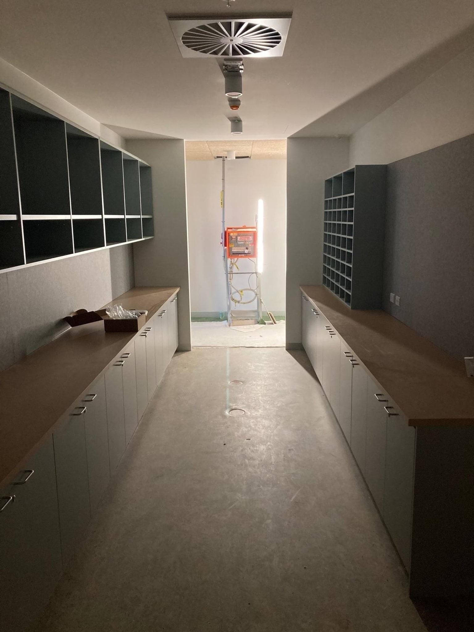 Interior of corridor with cupboards, shelves, and overhead ventilation