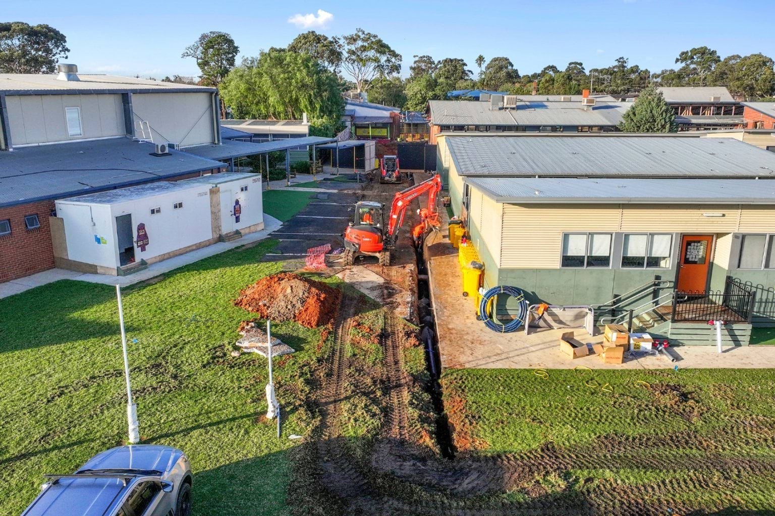 Low set buildings with an earth mover digging between them