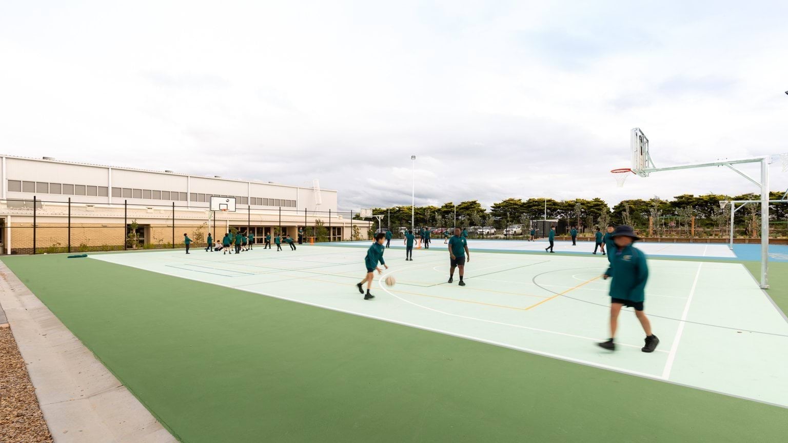 Students playing basketball on two basketball courts