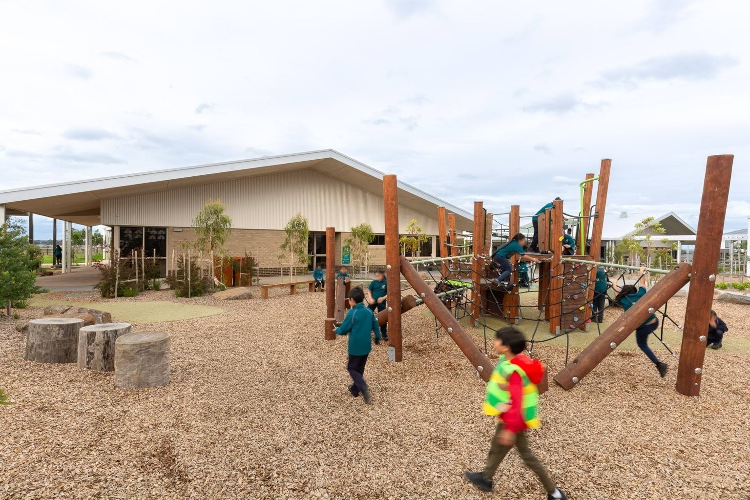 Children exploring playground area outside building
