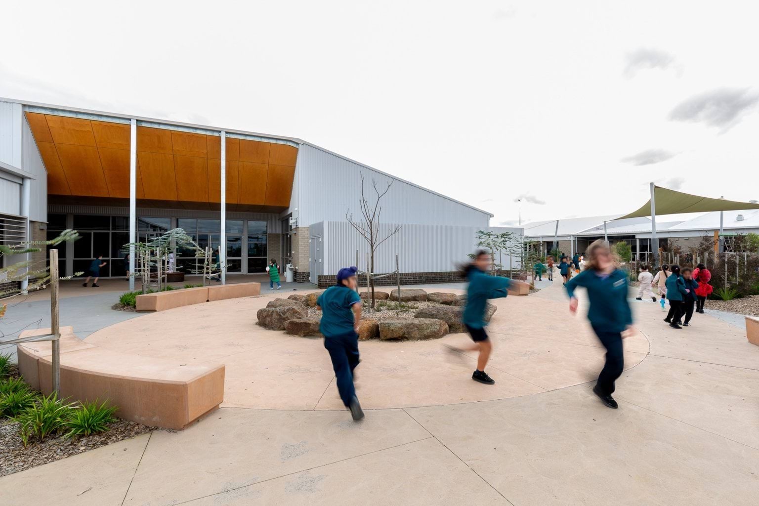 Students playing outside building in circular paved area