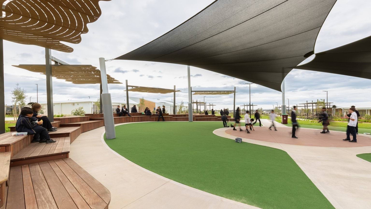 Students playing in covered outdoor area with benches