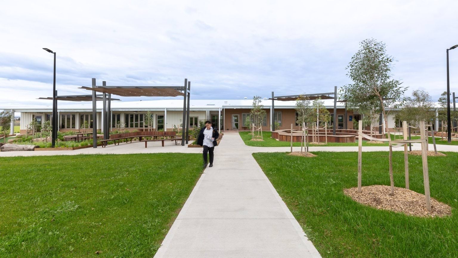 Student walking along paved area outside school building