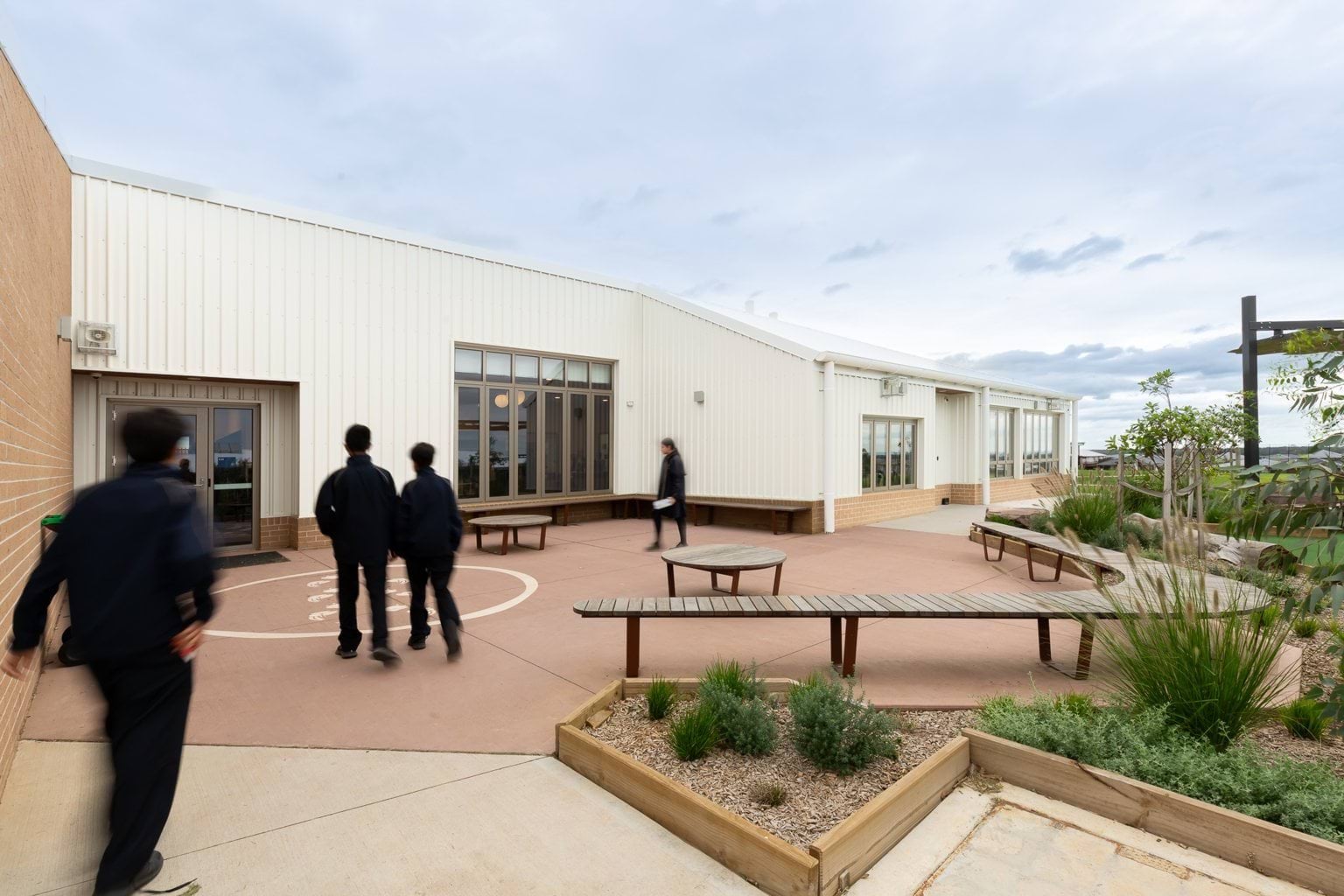 Students walk through seated area outside building