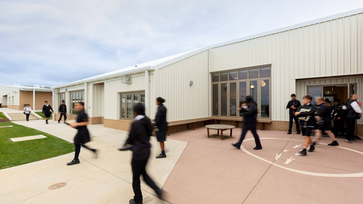 Students walking out of building on paved area