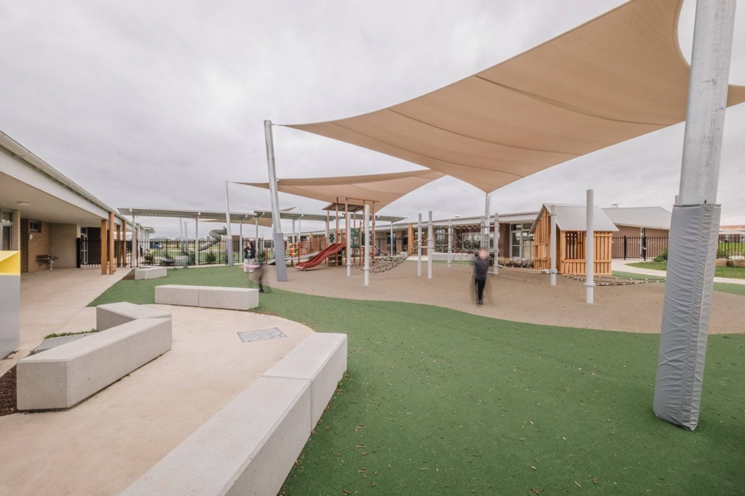 Outdoor covered play area with astro-turf, bench seats, and a playground