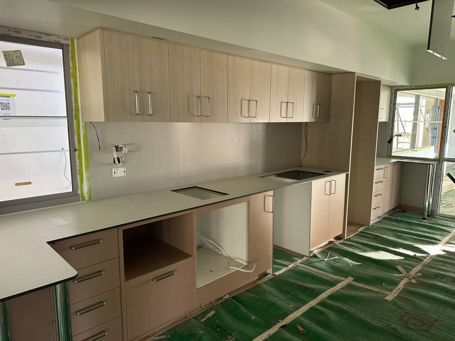A newly fitted kitchenette with cabinetry, benchtops and protective floor coverings