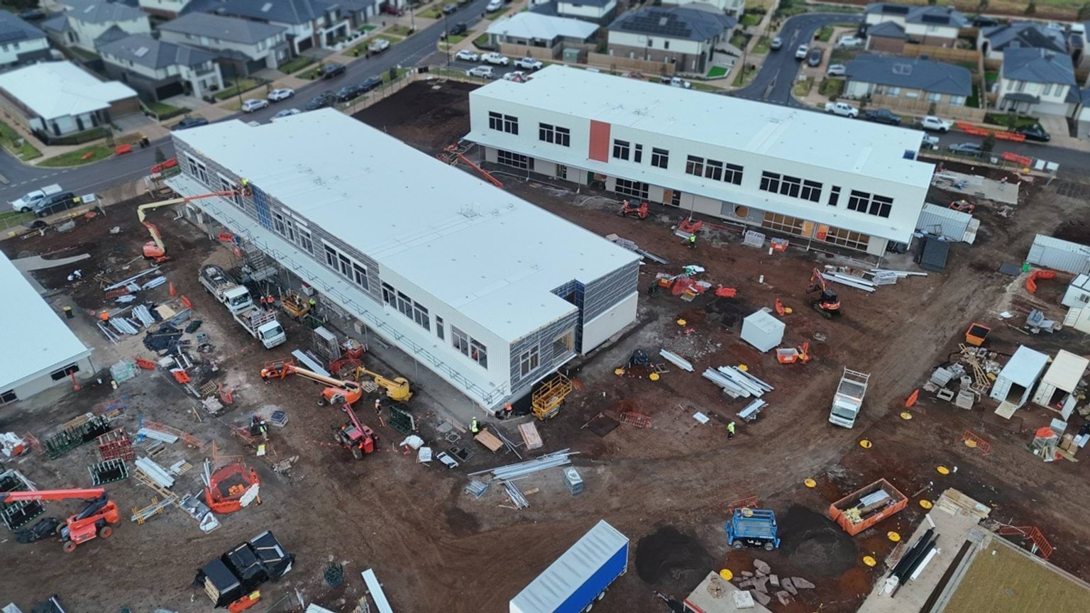 View from above of construction site with two large, multi-storey buildings