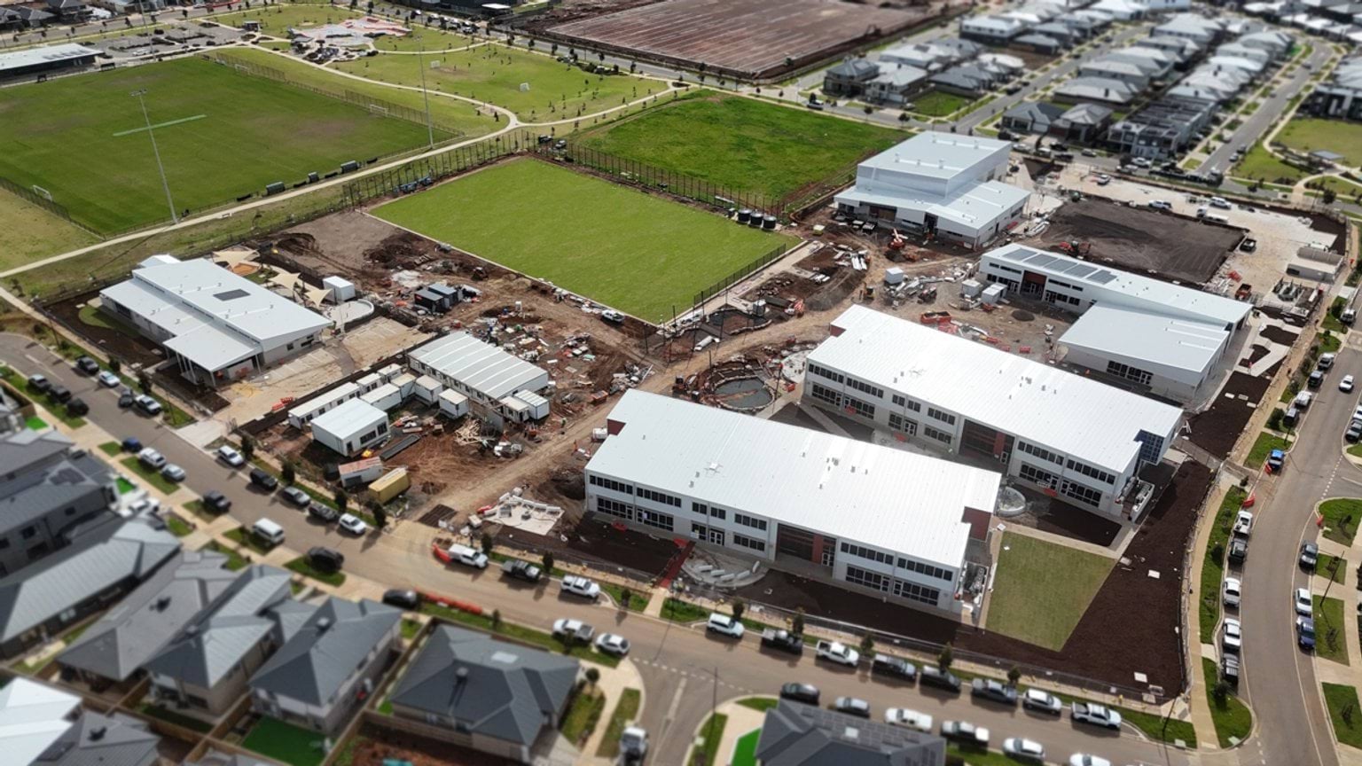 View from above of school site with landscaping and buildings at different stages of completion