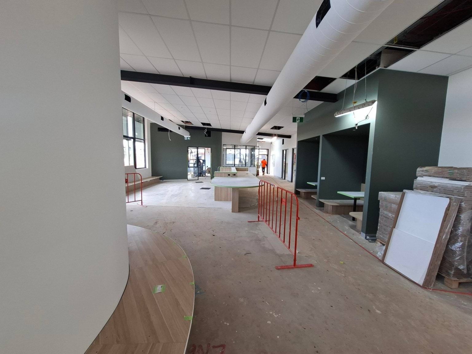 A break-out area under construction with green furnished fittings and curved bench seats. 