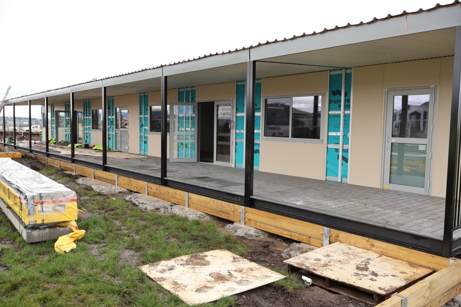 Modular construction site showing buildings with deck and outdoor shelter.