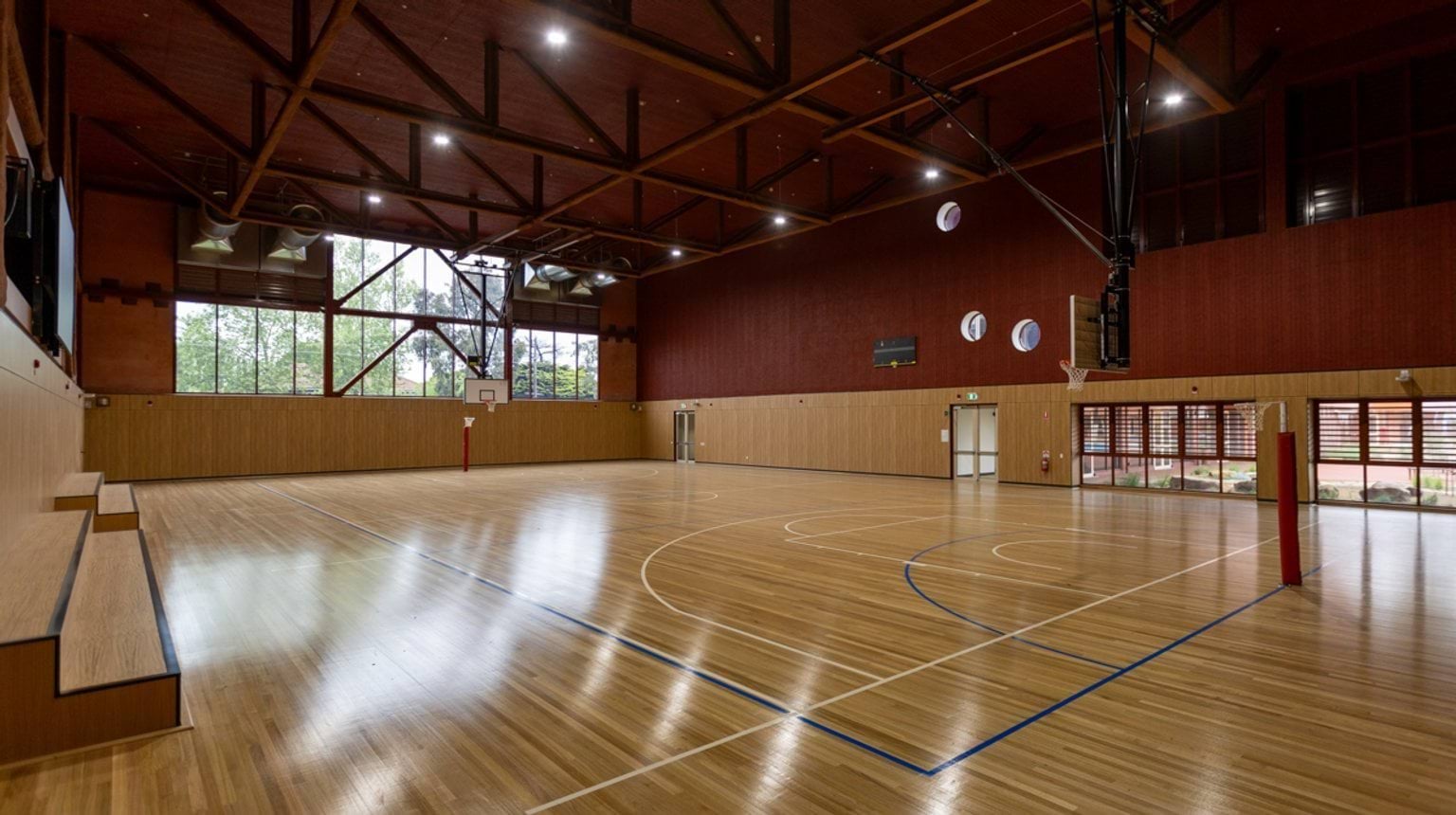 An indoor stadium with basketball rings and wooden benches