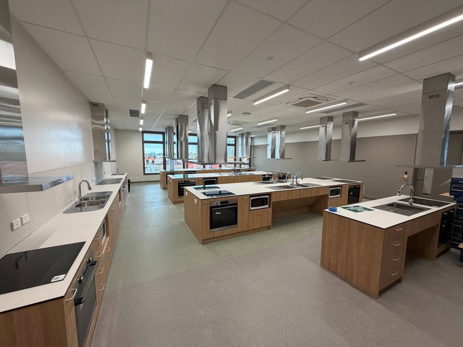 A food technology classroom with rows of benches, sinks and kitchenettes designed for practical classroom activities.